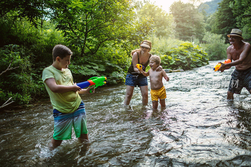 Family water fight in nature